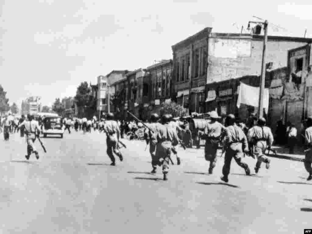 Soldiers chase rioters during civil unrest in Tehran.