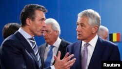 NATO Secretary-General Anders Fogh Rasmussen (left) talks to U.S. Defense Secretary Chuck Hagel during a NATO-Georgia defense ministers' meeting in Brussels in 2013.