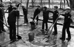 Removing puddles from school grounds ahead of the May 1 holiday in 1987.