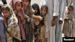 Children stand in line at a distribution center in Kurram.