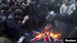 Protesters burn a British flag taken down from the British Embassy in Tehran.