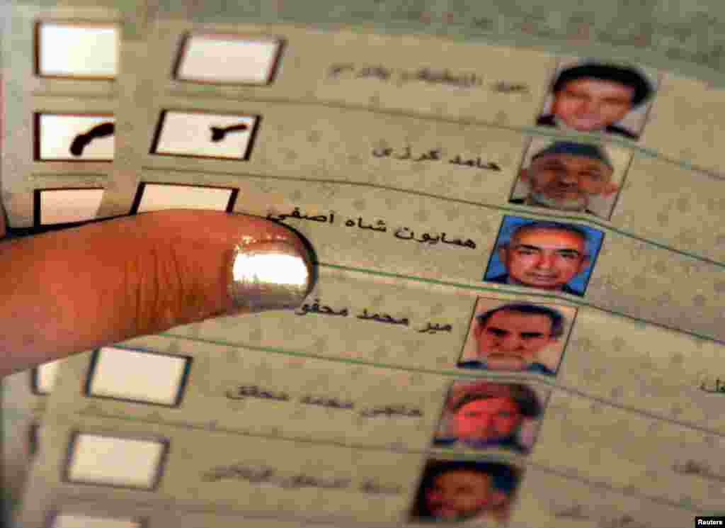 An Afghan election&nbsp;worker counts a vote for Karzai&nbsp;during the country&#39;s first post-Taliban presidential&nbsp;election,&nbsp;held on October 9, 2004. Karzai took the&nbsp;oath of office on December 7, 2004, for a five-year term as president. 