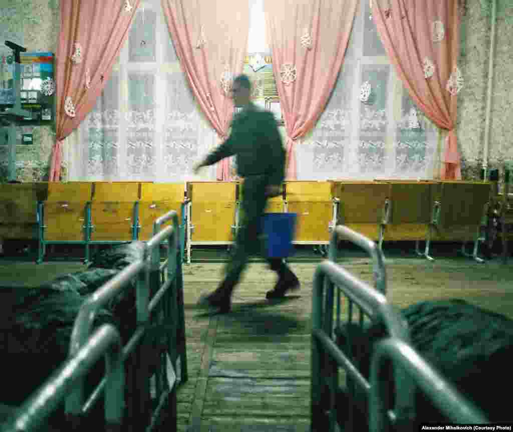 A soldier carries water to clean the barracks.