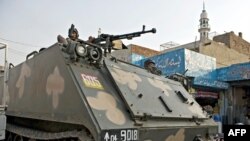 An armored personnel carrier patrols along a street in Lahore.