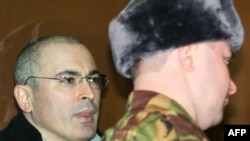 Mikhail Khodorkovsky (left) inside a bullet-proof glass dock in a Moscow court in March 2009