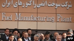 President Mahmud Ahmadinejad waves as he poses with officials outside Iran's fuel manufacturing plant during its inauguration ceremony.