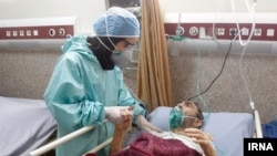 A nurse attends to a coronavirus patient in Iran.