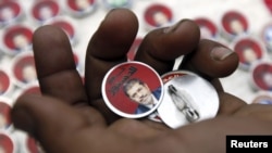 Badges showing an image of President Muhammad Morsi and the words "Yes To Constitution" are displayed at a street stall in Cairo.