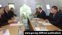 Uzbek Prime Minister Abdulla Aripov (right) meets with with Kyrgyz Deputy Prime Minister Kubatbek Boronov at a border crossing on June 1.