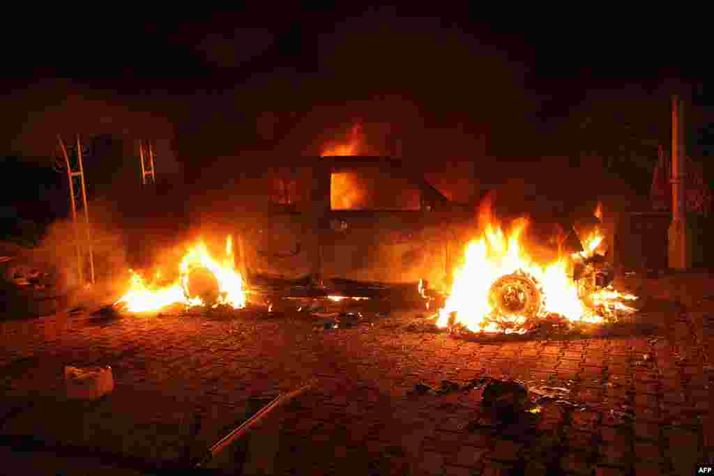 Vehicles are engulfed in flames after they were set on fire inside the U.S. Consulate compound.