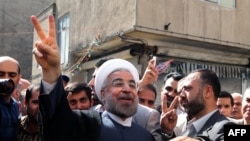 Hassan Rohani flashes the sign of victory as he leaves a polling station after voting in Tehran on June 14.