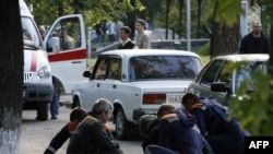 Medics and police help a wounded person after the bombing in Stavropol on May 26.