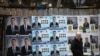 A woman walks past election posters of the ruling center-right GERB party in the town of Dupnitsa, Bulgaria, April 2, 2021.