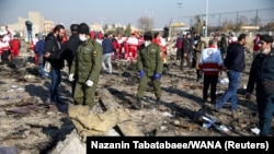 Security officers and Red Crescent workers are seen at the site where the Ukraine International Airlines plane crashed after takeoff from Iran's Imam Khomeini Airport, on the outskirts of Tehran, on January 8. 