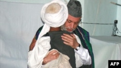 President Karzai embraces a man from Bala Buluk, where a U.S. air strike killed 140 civilians 