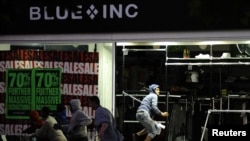 Looters run from a clothing store in Peckham, London, on August 8.