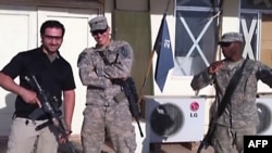 A TV grab shows a man (left) believed to be Amir Mirza Hekmati posing with U.S. troops at an unspecified location.