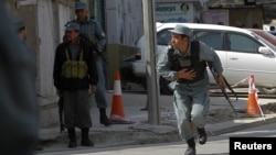 Afghan police officers take up positions during the attacks in Kabul on April 15.