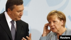 German Chancellor Angela Merkel (right), seen at a 2010 meeting with Ukrainian President Viktor Yanukovych, has threatened to stay away from Ukraine during Euro 2012.