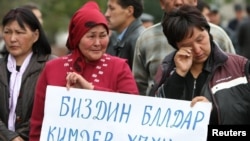 Friends and relatives of people killed during the April uprising that drove the former president from power rally against the policies of the Ata-Jurt party in Bishkek.