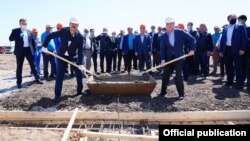 A hopeful sign of cooperation in Central Asia: Uzbek Prime Minister Abdullo Aripov (left) and his Kazakh counterpart, Askar Mamin, pose for photographs as repair work begins following the recent Sardob Reservoir disaster. 