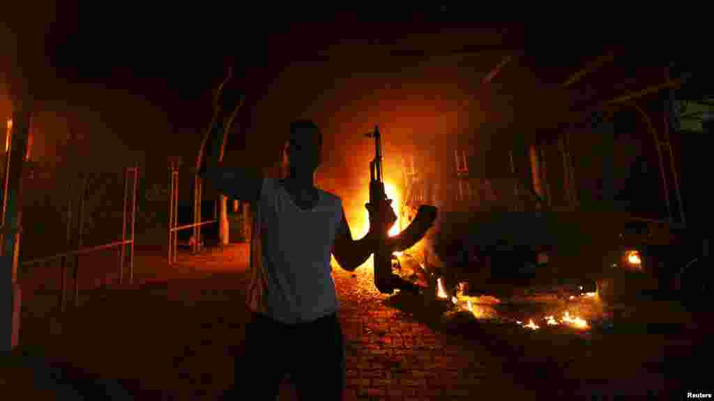 A gunman reacts as the U.S. Consulate compound in Benghazi burns behind him.