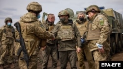 President Volodymyr Zelenskiy (center, visiting the eastern conflict zone in April) says he wants a clear "yes" or "no" from Biden on giving Ukraine a plan to join NATO.