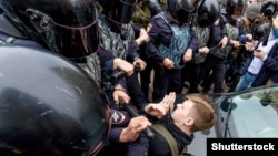 Russian police officers confront a teenager during a rally protesting hikes in the country's retirement age in St. Petersburg on September 9.