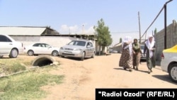 Women hurry to one of the inmates' funerals in Baghalak village, an event that relatives say was held with undue haste.