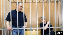 Former Yukos oil company CEO Mikhail Khodorkovsky (left) and Platon Lebedev in a Moscow courtroom -- will they receive more than moral compensation?