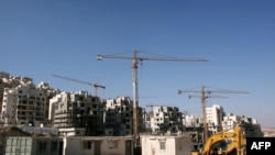 Construction cranes and excavators at the building sites of new housing units in the Jewish settlement of Har Homa in East Jerusalem