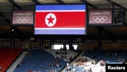 Spectators sit in the stands under the proper North Korean national flag ahead of their women's Group G football match against Colombia.