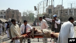 Volunteers transport an injured victim at the scene of the suicide car-bomb attack in Lahore on May 27. 