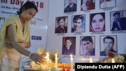 An Indian journalist lights candles during a vigil for Afghan journalists who were killed in a targeted suicide bombing in April, including two reporters who worked for RFE/RL's Radio Free Aghanistan, as well as a female trainee.