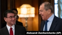 Russian Foreign Minister Sergei Lavrov (right) and Japanese Foreign Minister Taro Kono enter a hall for their talks in Moscow on January 14.