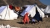 Afghan migrants in Nangarhar Province sit outside tents at a makeshift camp upon their arrival after being returned from Pakistan on November 12. 