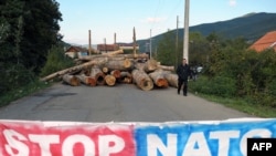 Kosovo -- An ethnic Serb man passes by a barricade set up in the village of Zupce.