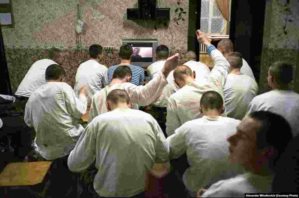 The evening routine: mending uniforms in front of the state-run news broadcast. When the officers leave, the men change the channel to an action movie. 