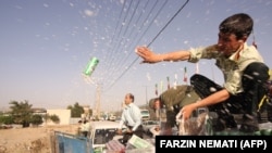 Iranian police throw away confiscated beer cans in Tehran in 2009. 