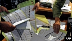 Afghan election workers go through ballots during the audit and recount process at the Independent Election Commission warehouse.