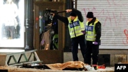 Police forensics experts examine the remains of a suspected suicide bomber in Stockholm.