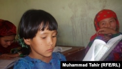 A young girl learns to read at school in Tarbuz Guzar.