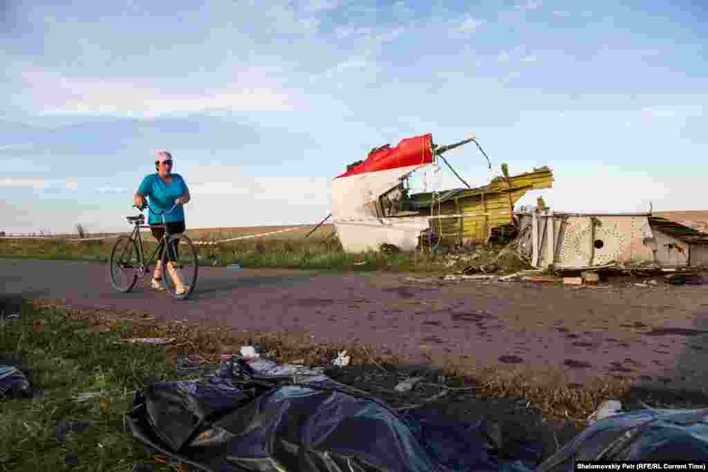 A woman passes by the wreckage of MH17 on July 20, 2014.