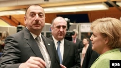 The president of Azerbaijan, Ilham Aliyev (left) chats with German Chancellor Angela Merkel (right) in Prague