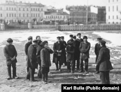 A group of men described in the original caption as “hooligans” loitering on a street in St. Petersburg around 1910. At least one of the men (in the center) is sporting a black eye.