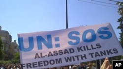 Antigovernment protesters carry a banner during a rally in the central city of Homs on May 6.