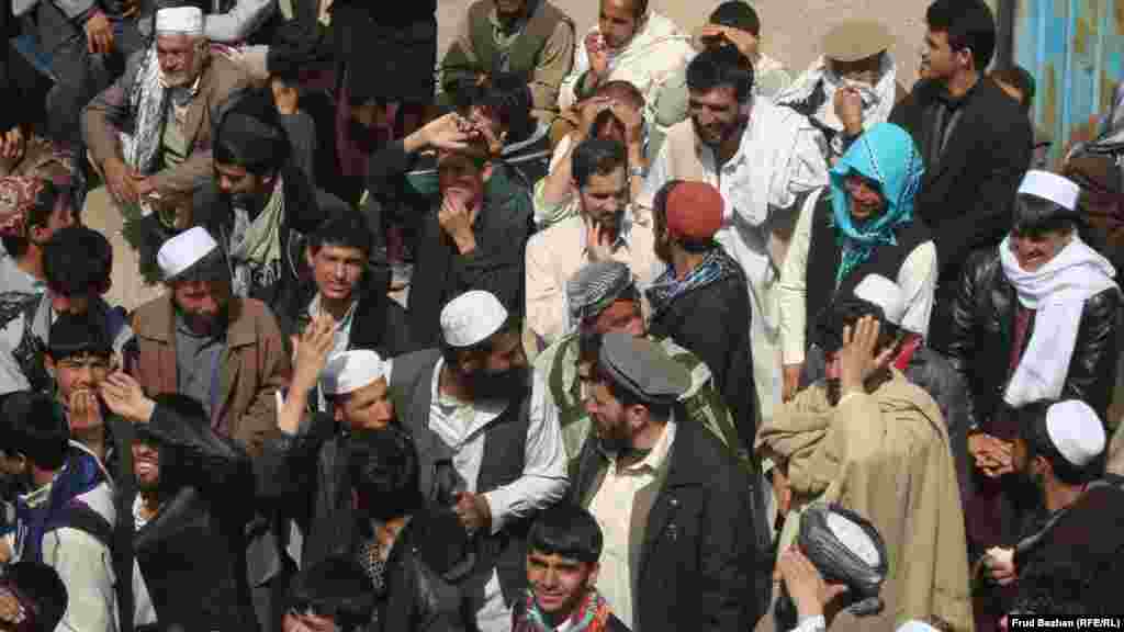 A crowd of men waits to enter a voter-registration office.