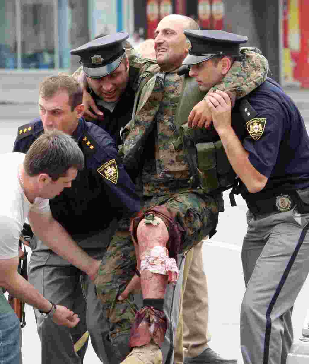 Policemen evacuate a Georgian soldier, wounded in battle with South Ossetian separatists, in the town of Gori.