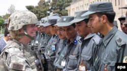 A US soldier congratulates Afghan police after training in Kabul