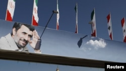 Iranian and Lebanese flags atop a billboard depicting Iranian President Mahmud Ahmadinejad in Beirut